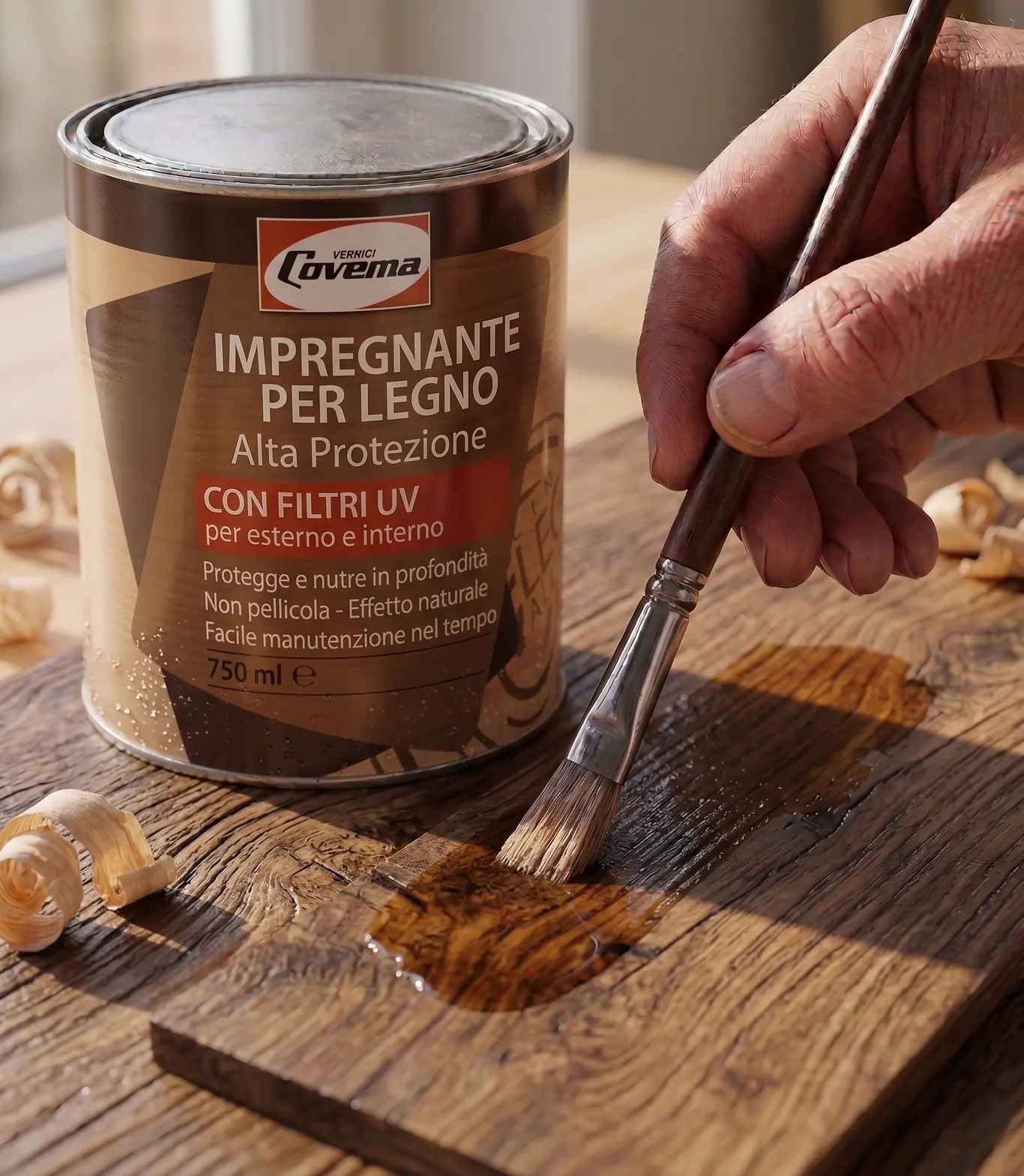 La latta dell'Impregnante per Legno Alta Protezione con filtri UV, accanto a una mano che stende il prodotto a pennello su una tavola di recupero