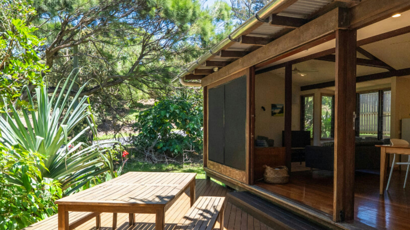 Tavolo e panche in legno su un ponte di legno sotto la veranda di una casa