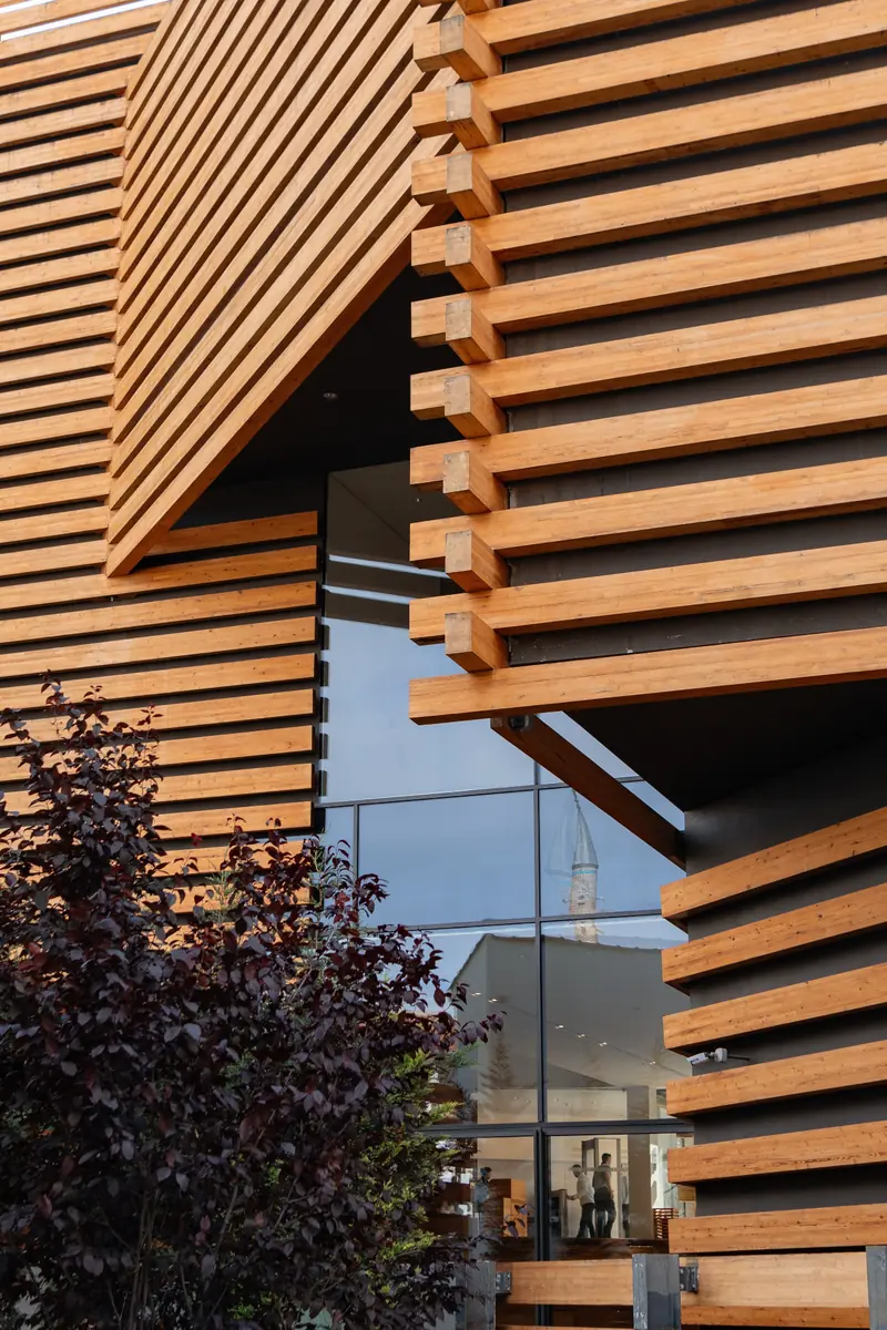 Facciata di un edificio contemporaneo con rivestimento a listelli di legno e ampie vetrate