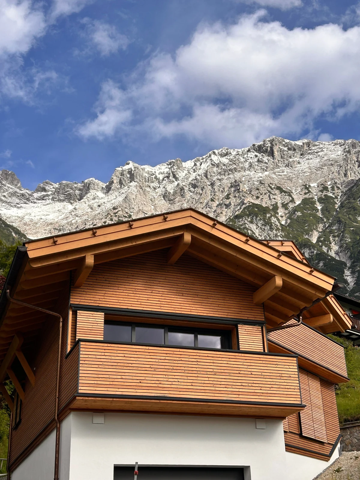 Casa rivestita in legno ai piedi delle montagne
