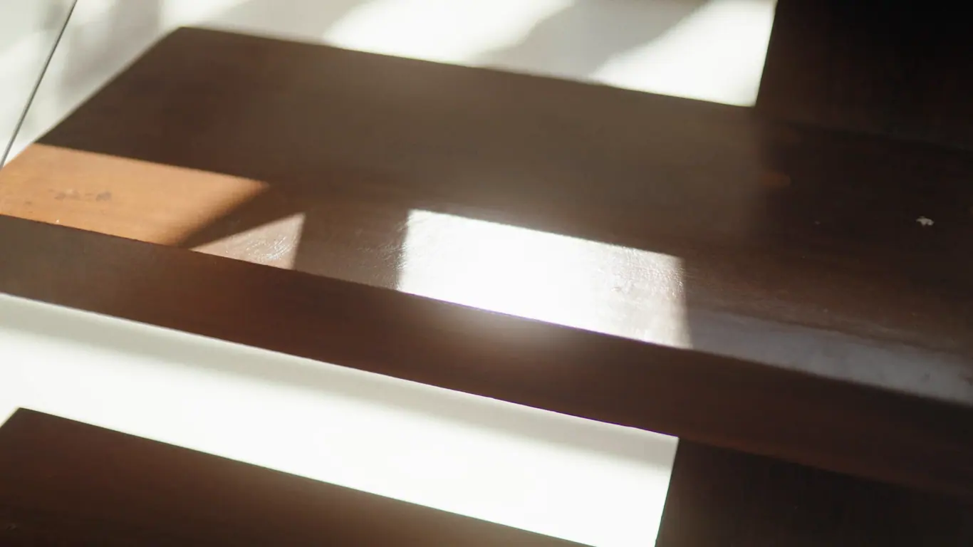 Assi di legno scuro con la luce radente di una finestra